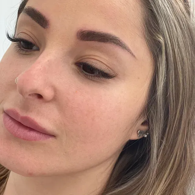 Un primer plano del rostro de una mujer con cabello largo y aretes.