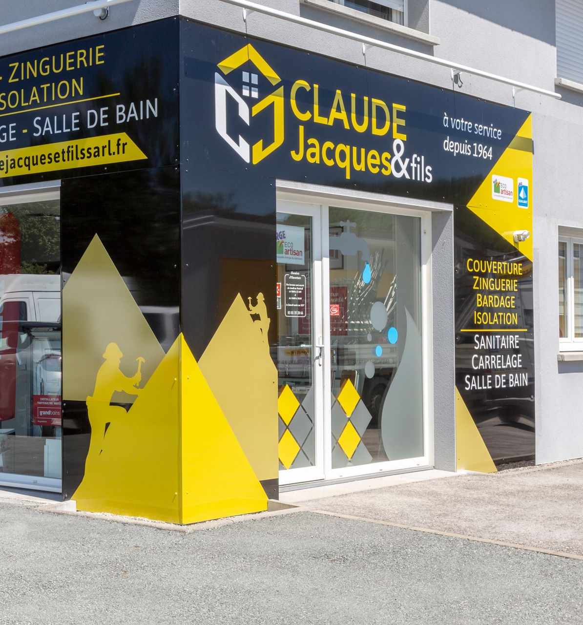 Extérieur de la boutique Claude Jacques & Fils, avec une enseigne jaune et noire et une porte d’entrée vitrée