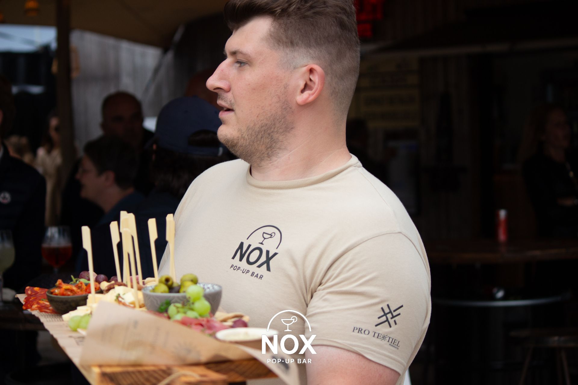 Mensen lachen terwijl ze aan een restauranttafel eten, drinken en genieten van de warme verlichting.