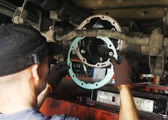 Mecánico instalando junta en diferencial de coche, en un garaje.