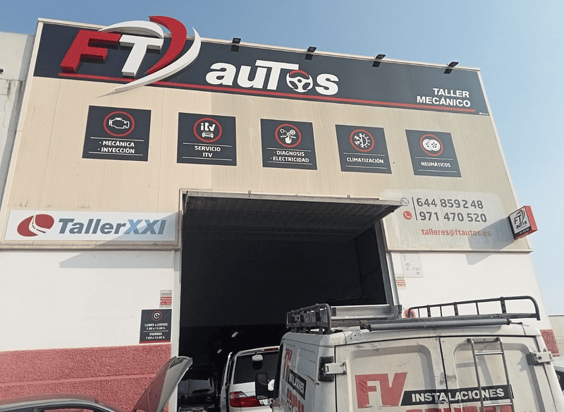 Garaje FT Autos con puerta abierta, vehículo, señalización e iconos de servicio.