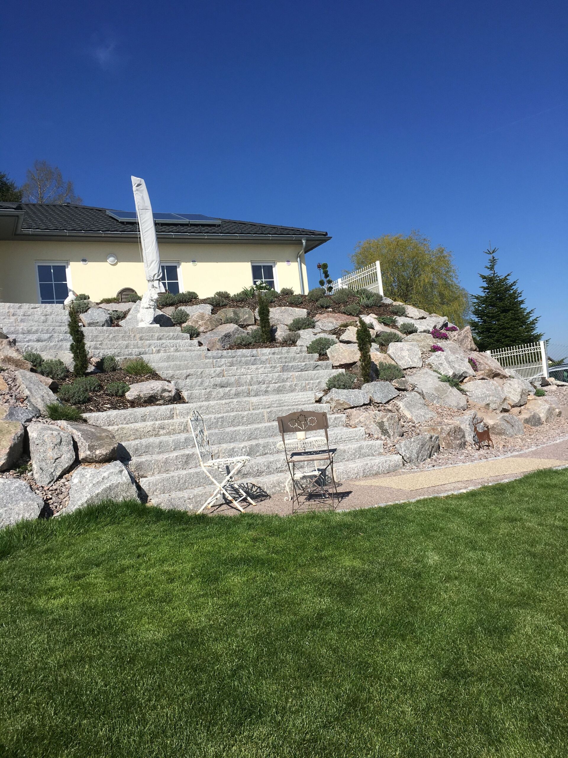 Steingarten mit Bepflanzung vor dem Haus