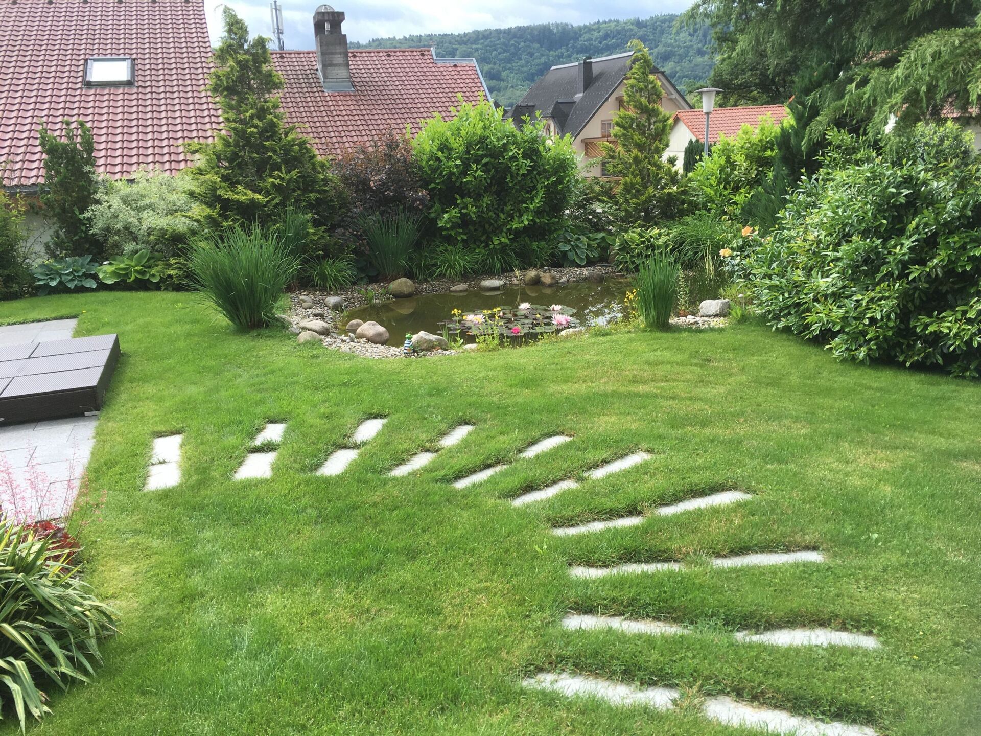 Gartenweg auf gepflegtem, kurzen Rasen zum Haus
