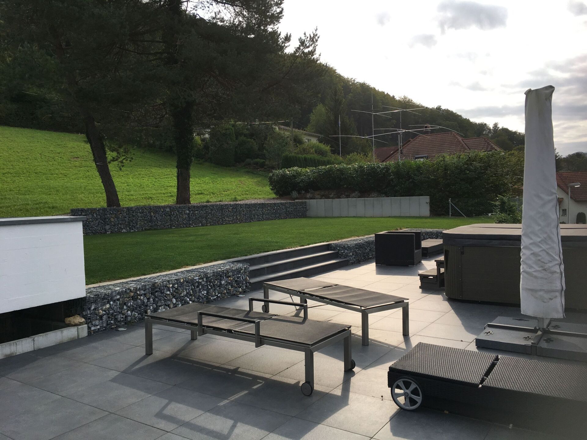 grau gefließte Terrasse mit Liegestühlen