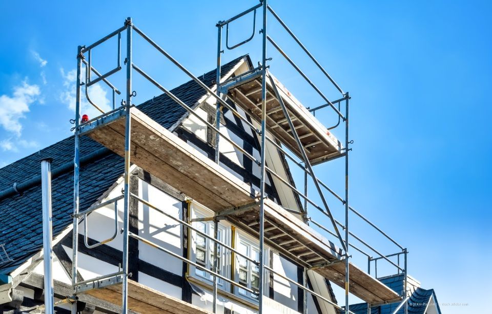 Baugerüst an einem im Bau befindlichen Gebäude vor blauem Himmel