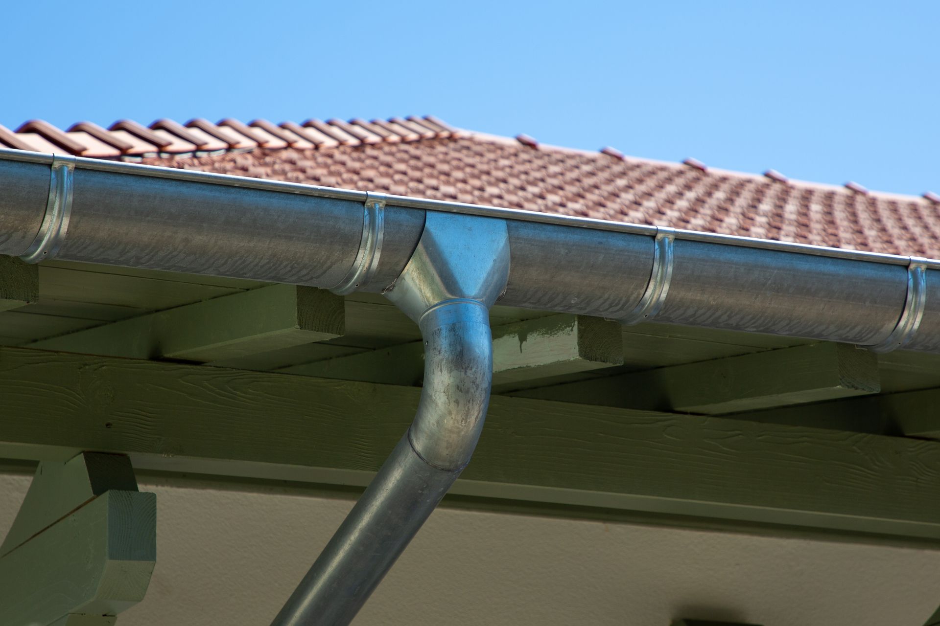 Gouttière en zinc sur un toit en tuiles