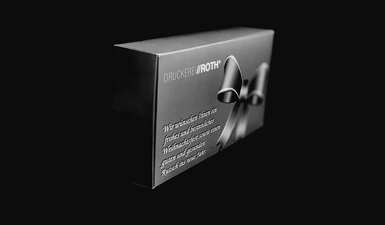 Ein Schwarzweißfoto einer Schachtel mit einer Schleife darauf.