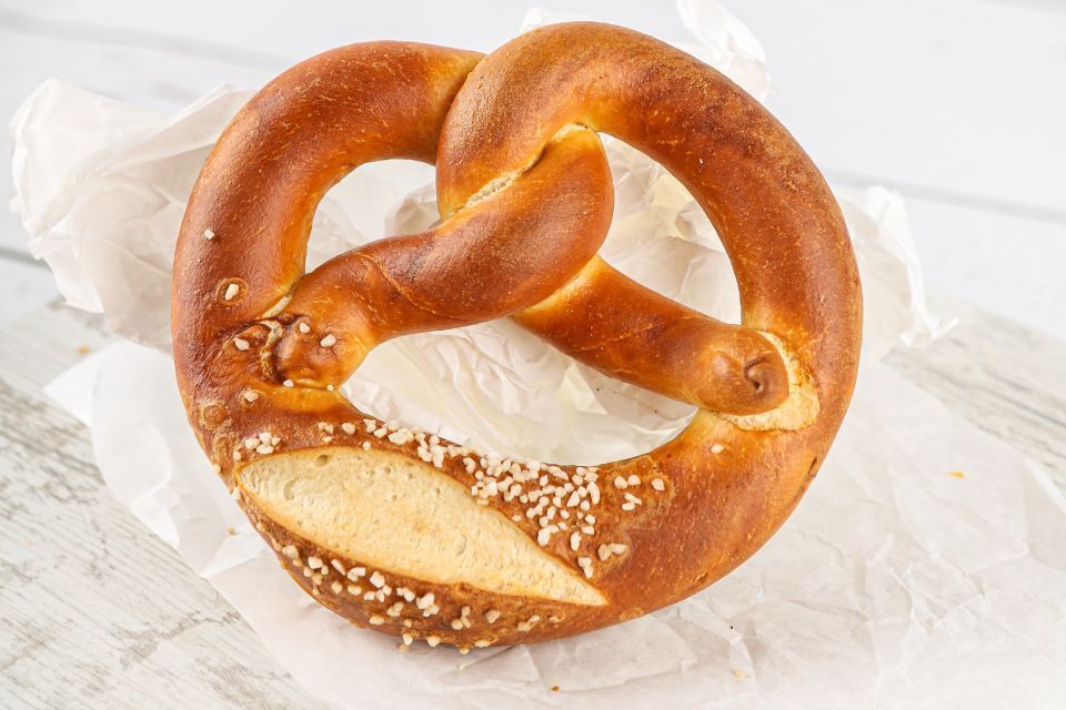 Weiche Brezel mit grobem Salz auf Pergamentpapier.