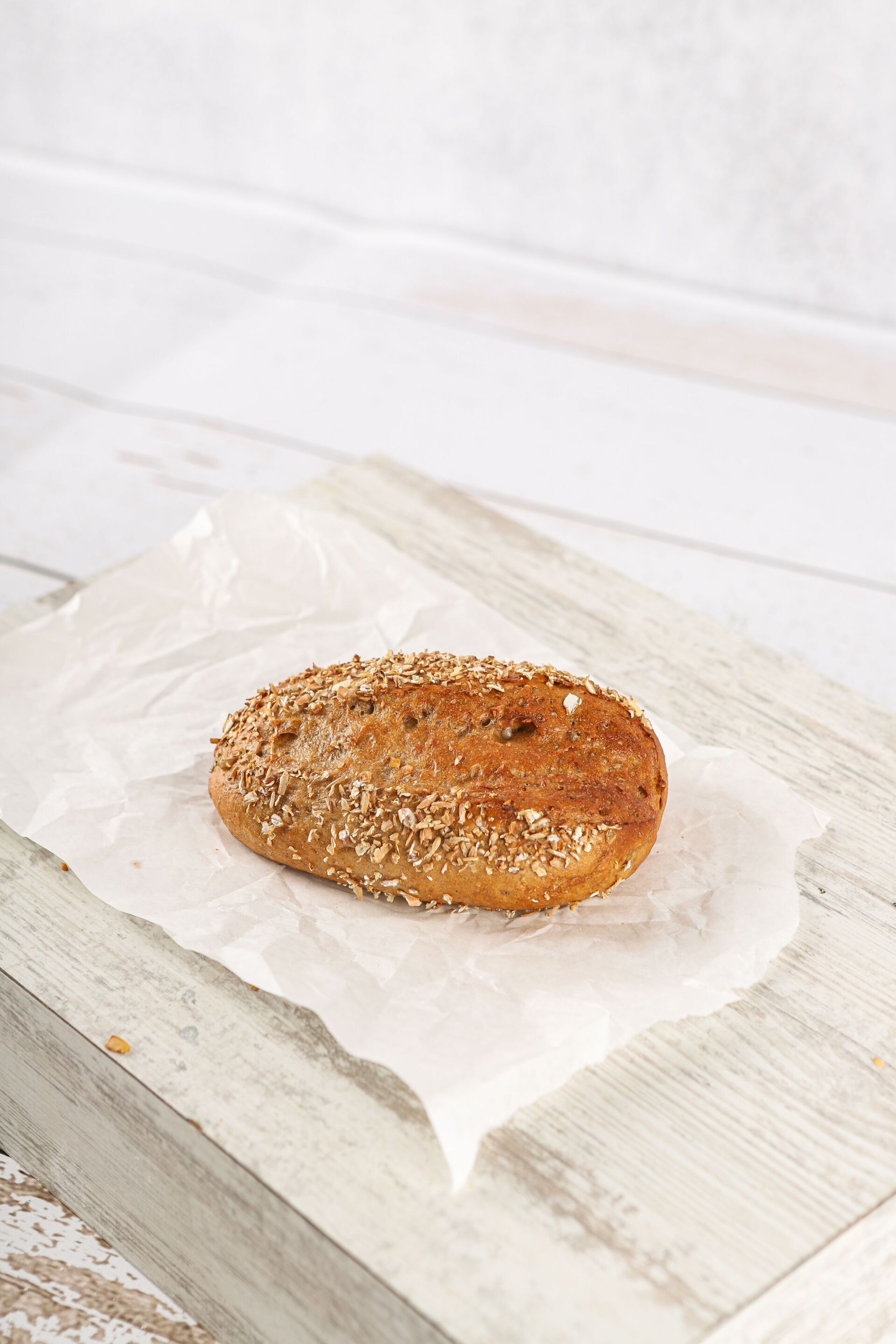 Bagel auf weißem Pergamentpapier auf einem Holzbrett.