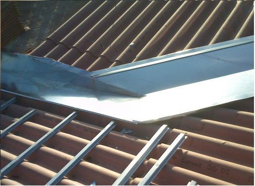 Un techo con una canaleta de metal encima