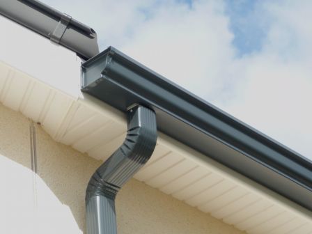 Un primer plano de una canaleta en el costado de un edificio.