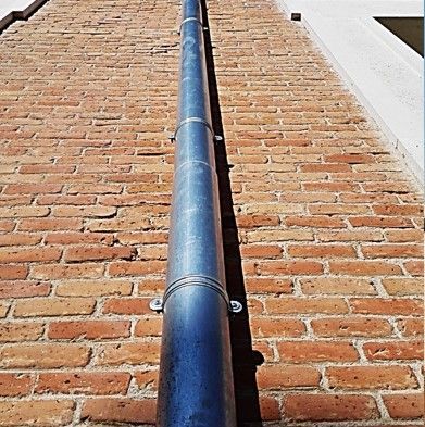 Una pared de ladrillos con una tubería azul encima