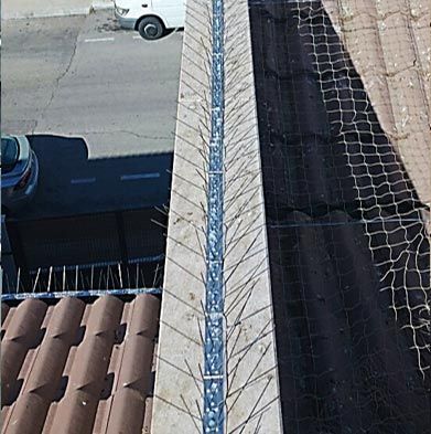 Una camioneta blanca está estacionada al costado de un edificio al lado de un techo.