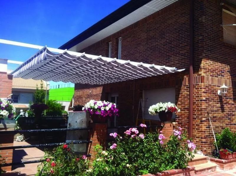 Una casa de ladrillo con un toldo blanco sobre el porche