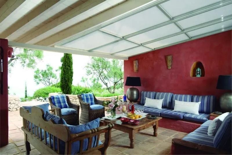 Una sala de estar con muebles azules y blancos y una pared roja.