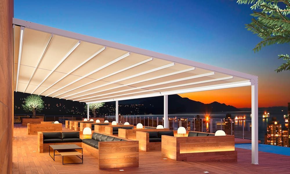 Un patio con pérgola y una piscina por la noche.