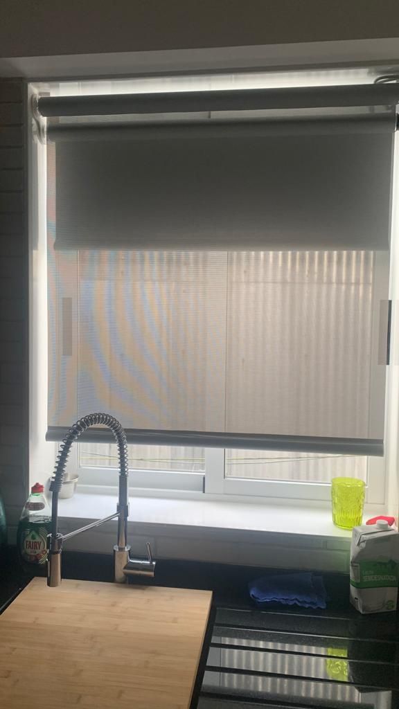 Una cocina con fregadero y una ventana con persianas.