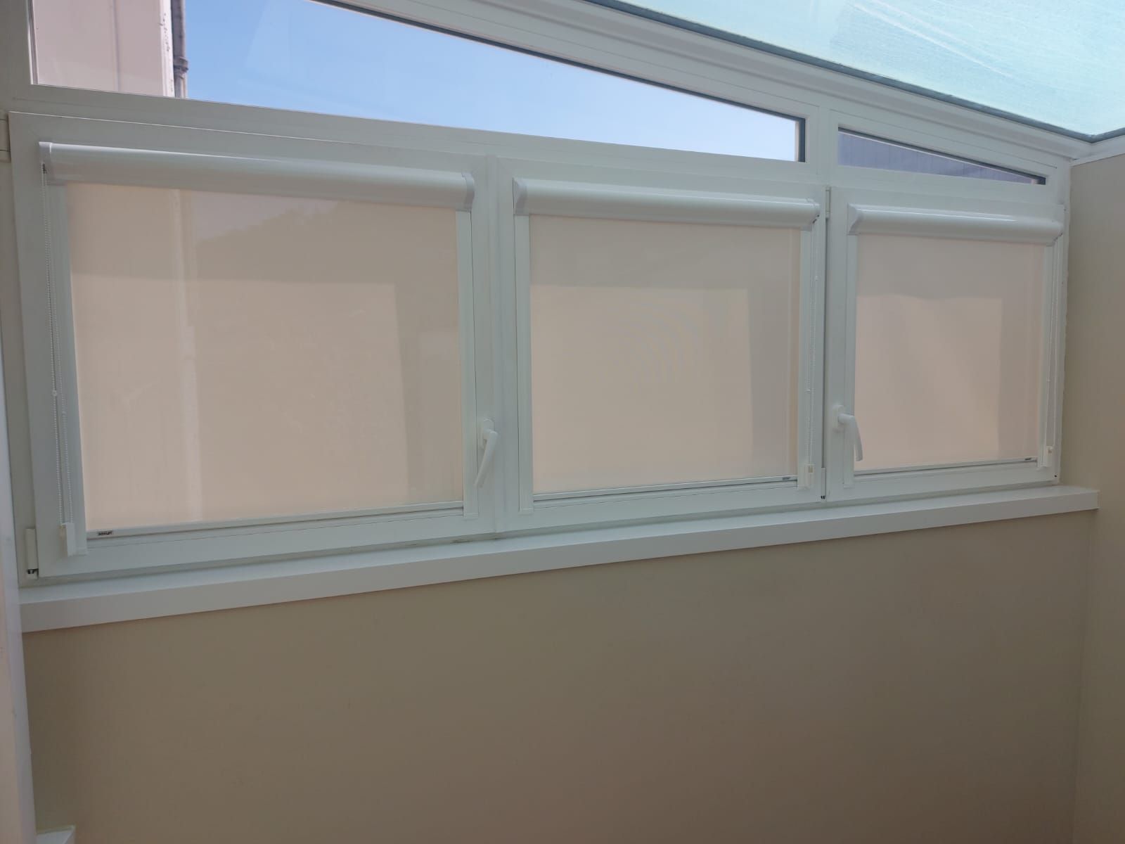 Hay tres ventanas con persianas en una habitación.