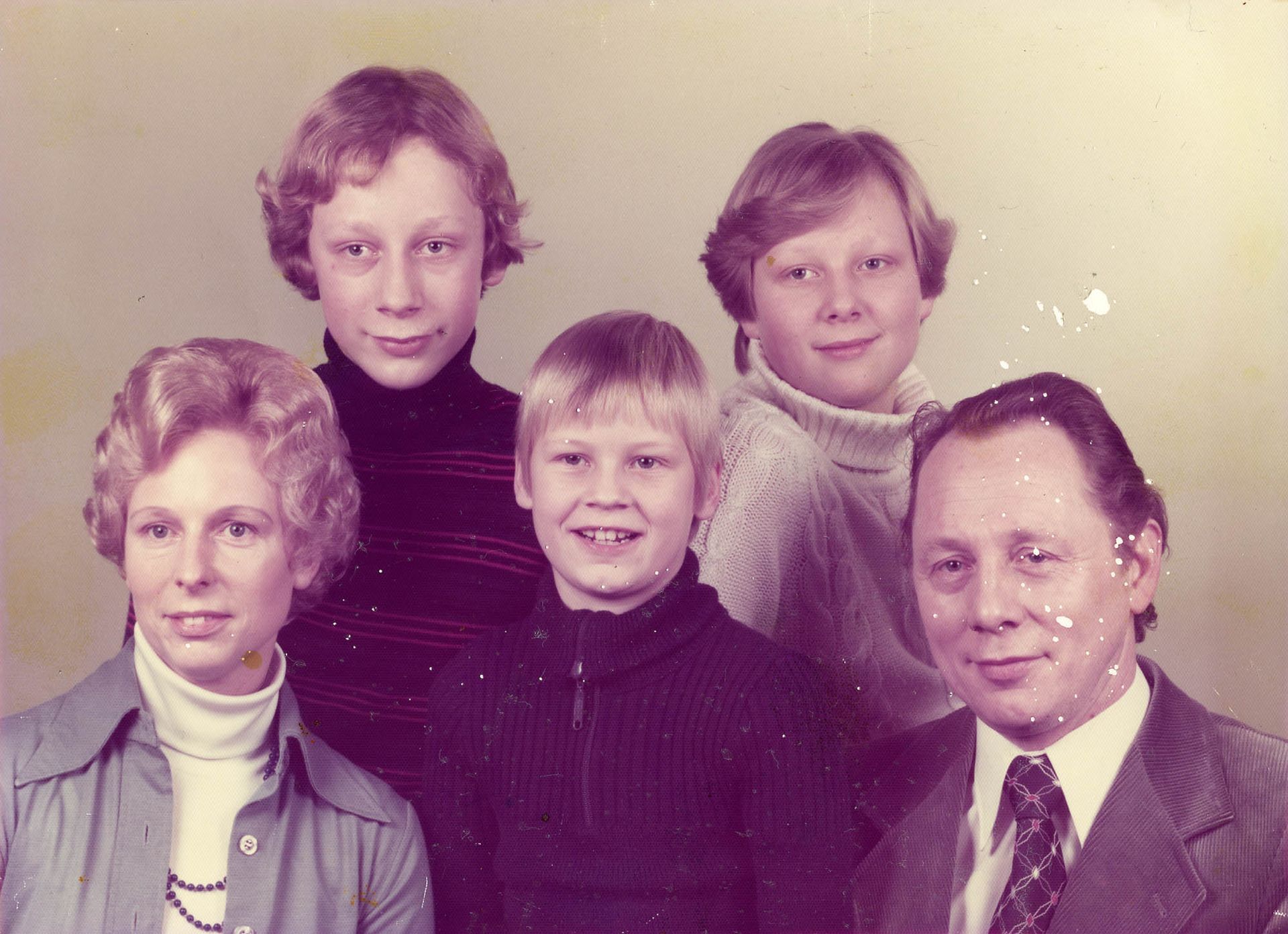 Eine Familie posiert für ein Foto mit einem Mann in Anzug und Krawatte