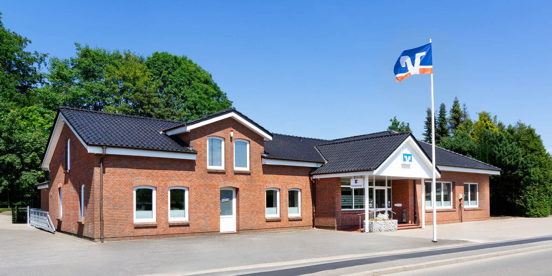 Ein großes Backsteingebäude mit einer blau-roten Flagge davor