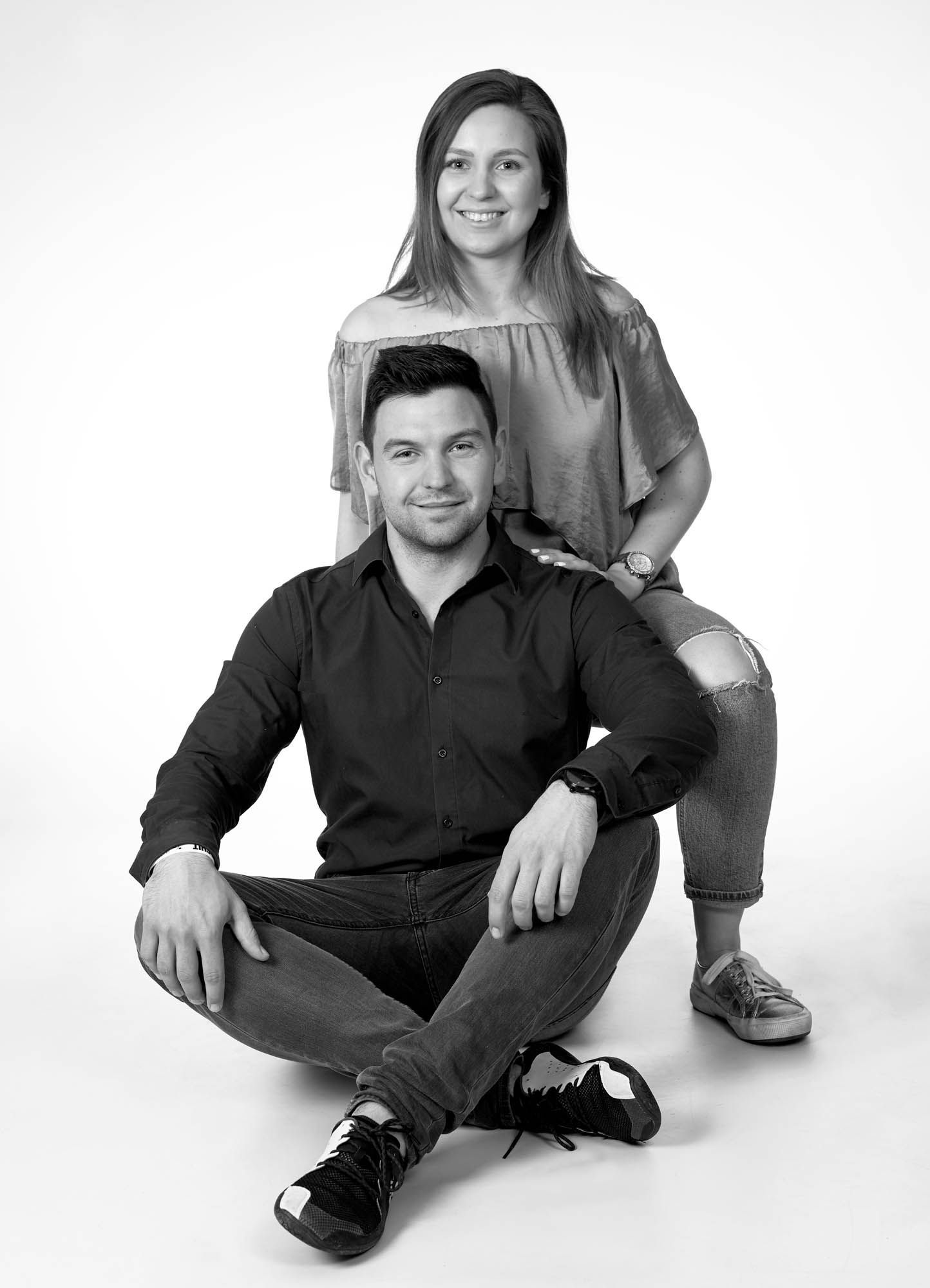 Ein Schwarzweißfoto eines Mannes und einer Frau, die auf dem Boden sitzen.