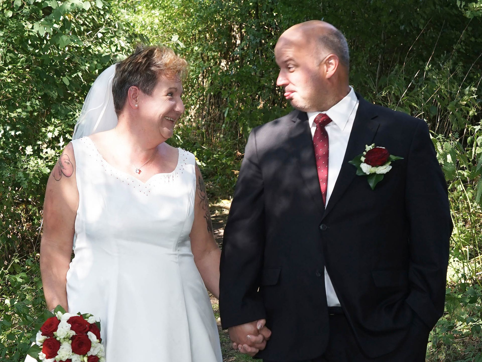 Braut und Bräutigam halten Händchen und lächeln einander an