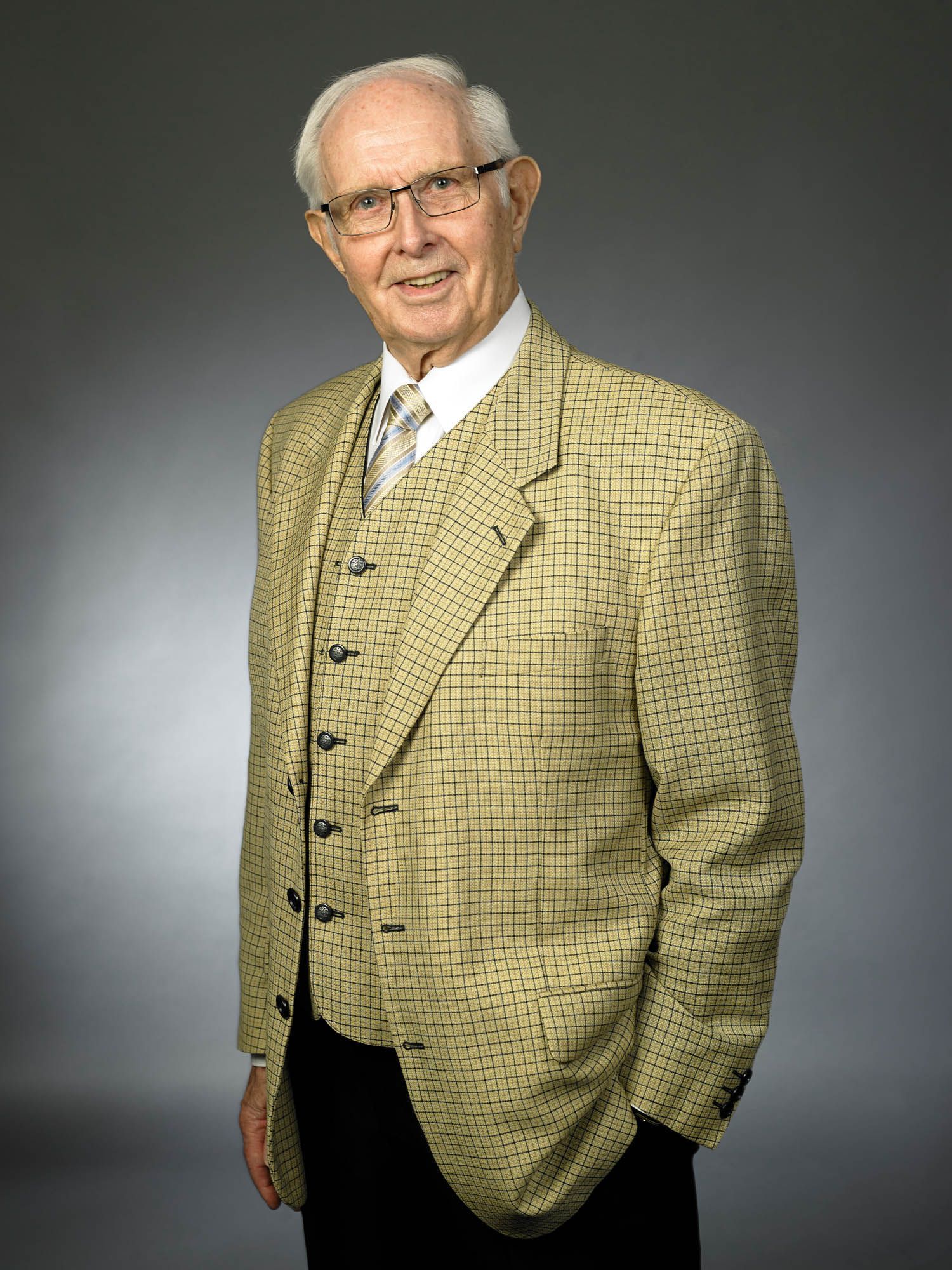 Ein Mann in Anzug und Krawatte mit den Händen in den Taschen