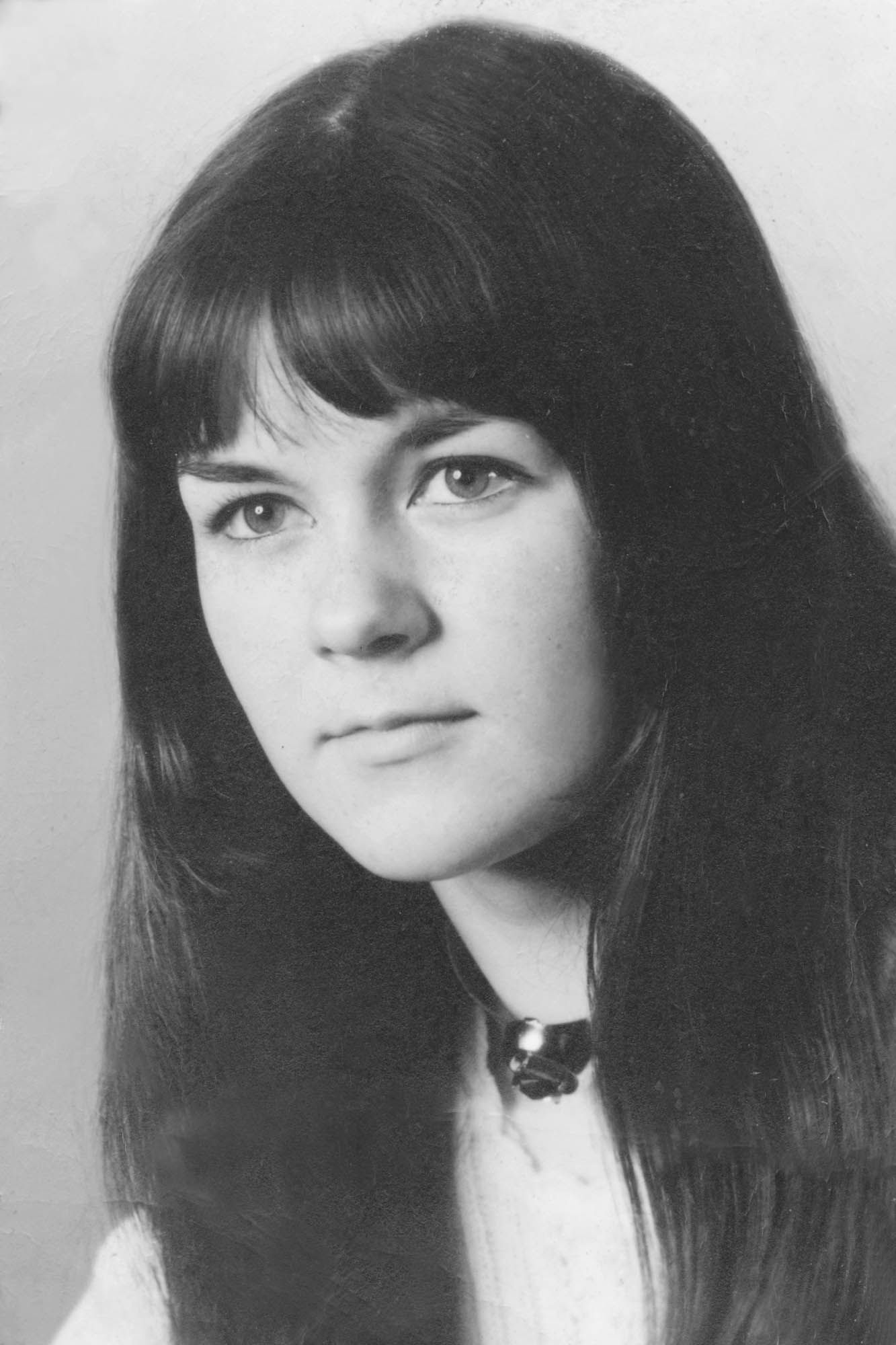 Ein Schwarzweißfoto einer jungen Frau mit langen Haaren und Pony.