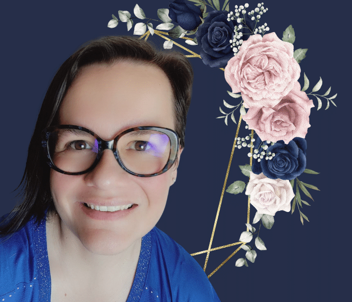 Personne souriante portant des lunettes sur fond bleu marine, encadrée de fleurs bleu marine, roses et blanches