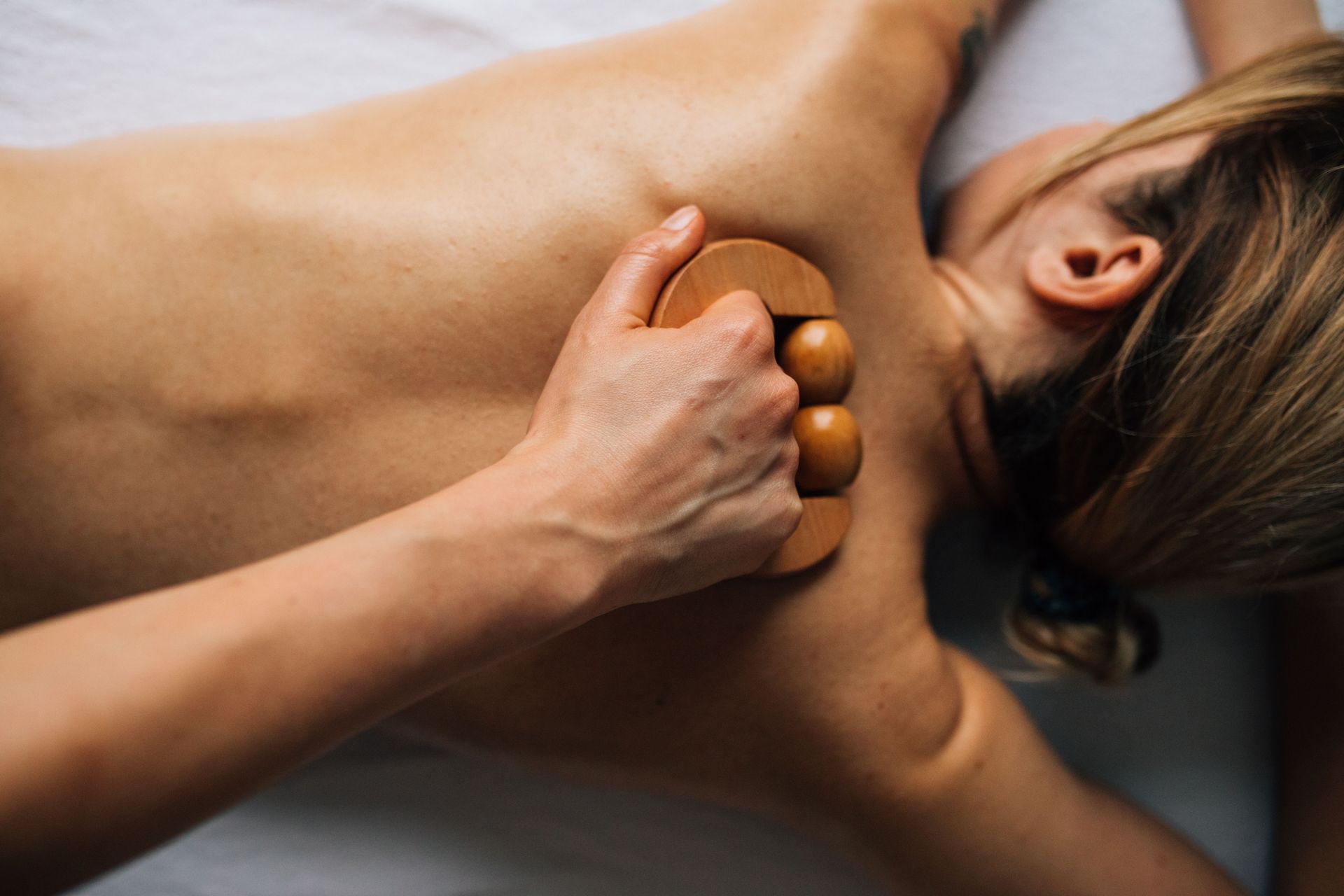 Femme recevant un massage du visage avec un bandeau blanc dans un spa