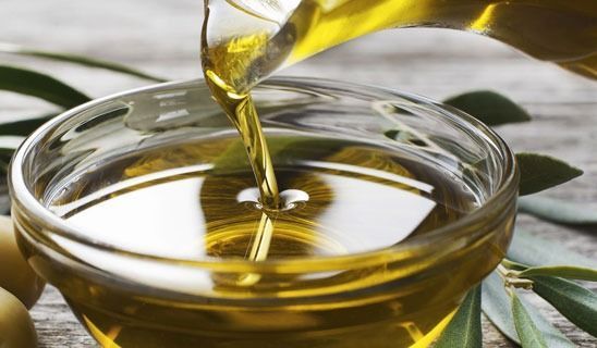 Se vierte aceite de oliva en un recipiente de vidrio.