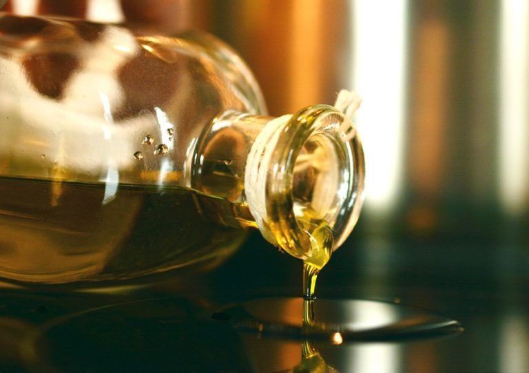 Se vierte una botella de aceite de oliva en un recipiente.
