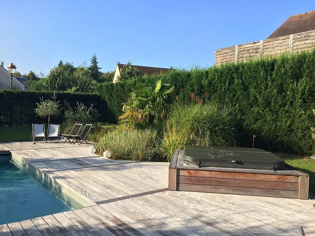 Terrasse en bois autour d'une grande piscine creusée