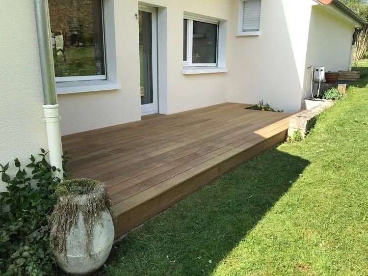 Gros plan sur une terrasse en bois dans un grand jardin