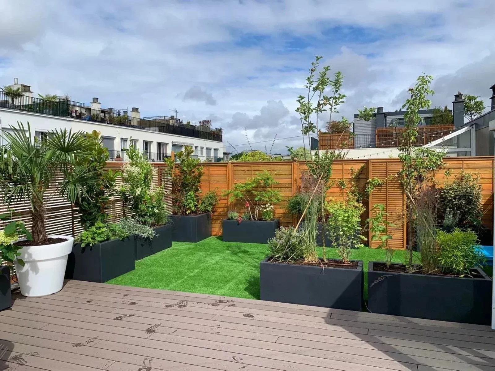 Un rooftop avec terrasse en bois et décorations végétales