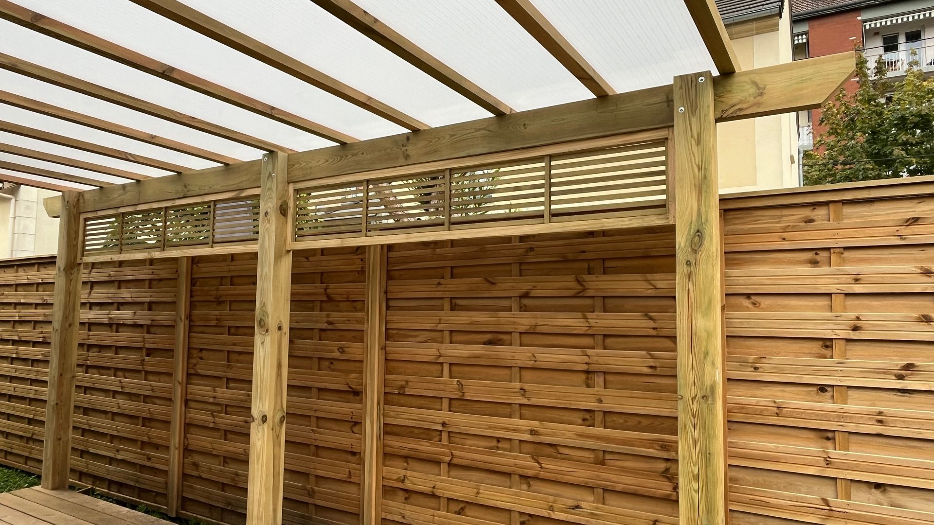 Terrasse végétalisée en bois avec table et chaises en teck foncé