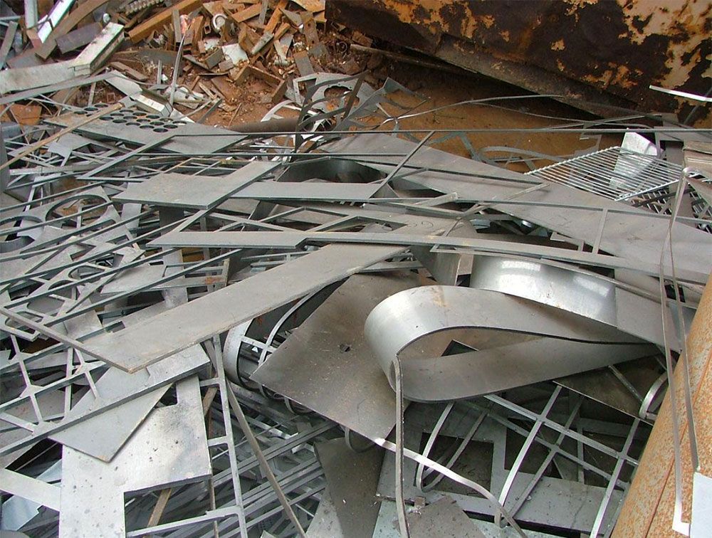 Tas de ferraille, comprenant des tôles découpées, des profilés et des éléments de structure, à l'intérieur d'une installation de recyclage.