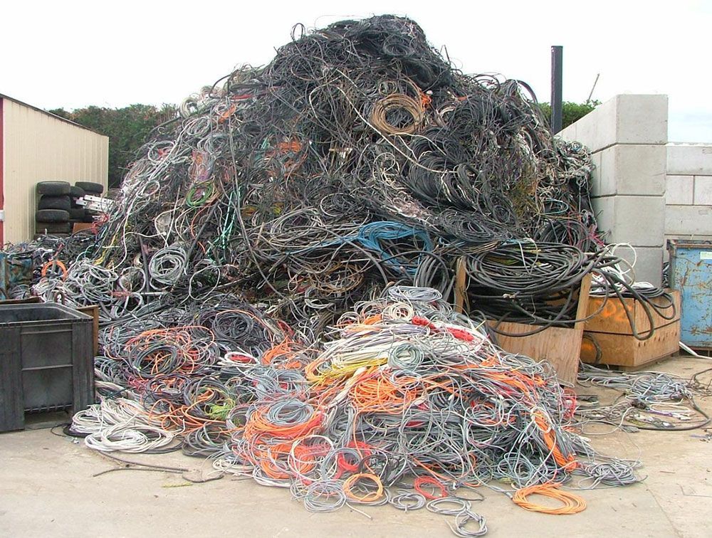 Tas de fils électriques mis au rebut dans un centre de recyclage ; on distingue différentes couleurs.