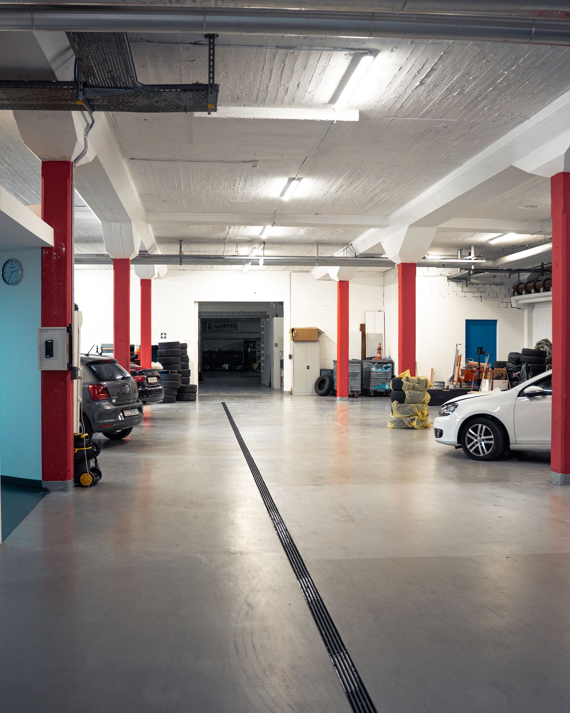 Ein Mann arbeitet in einer Garage an der Unterseite eines Autos