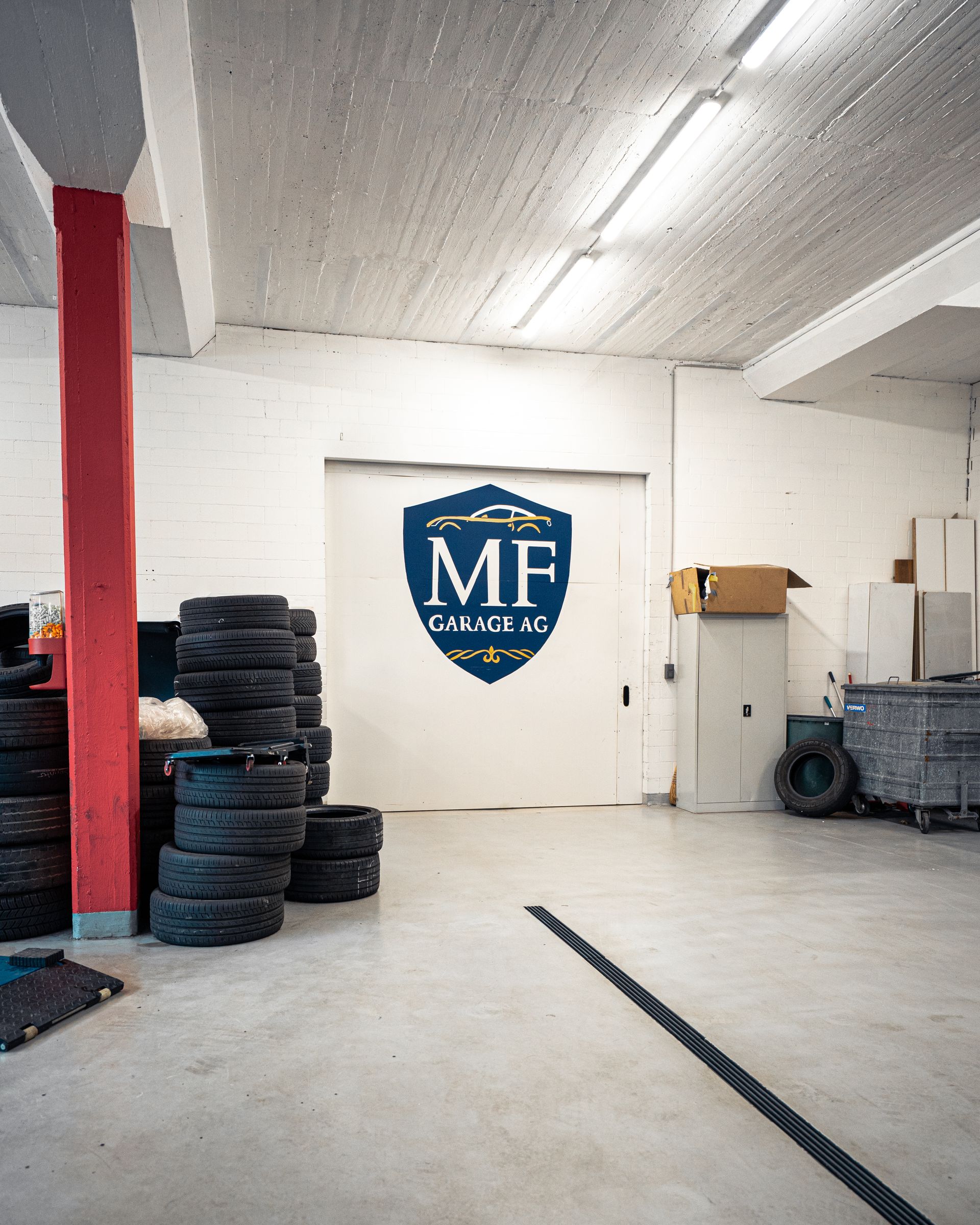 Ein Mann arbeitet in einer Garage am Motor eines Autos.