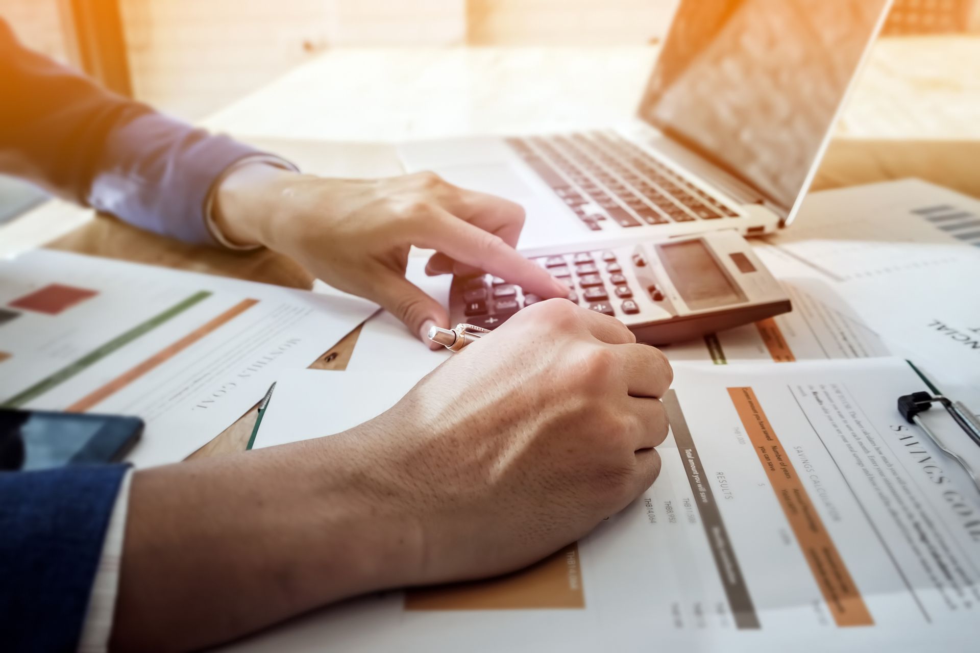 Des mains manipulant une calculatrice.