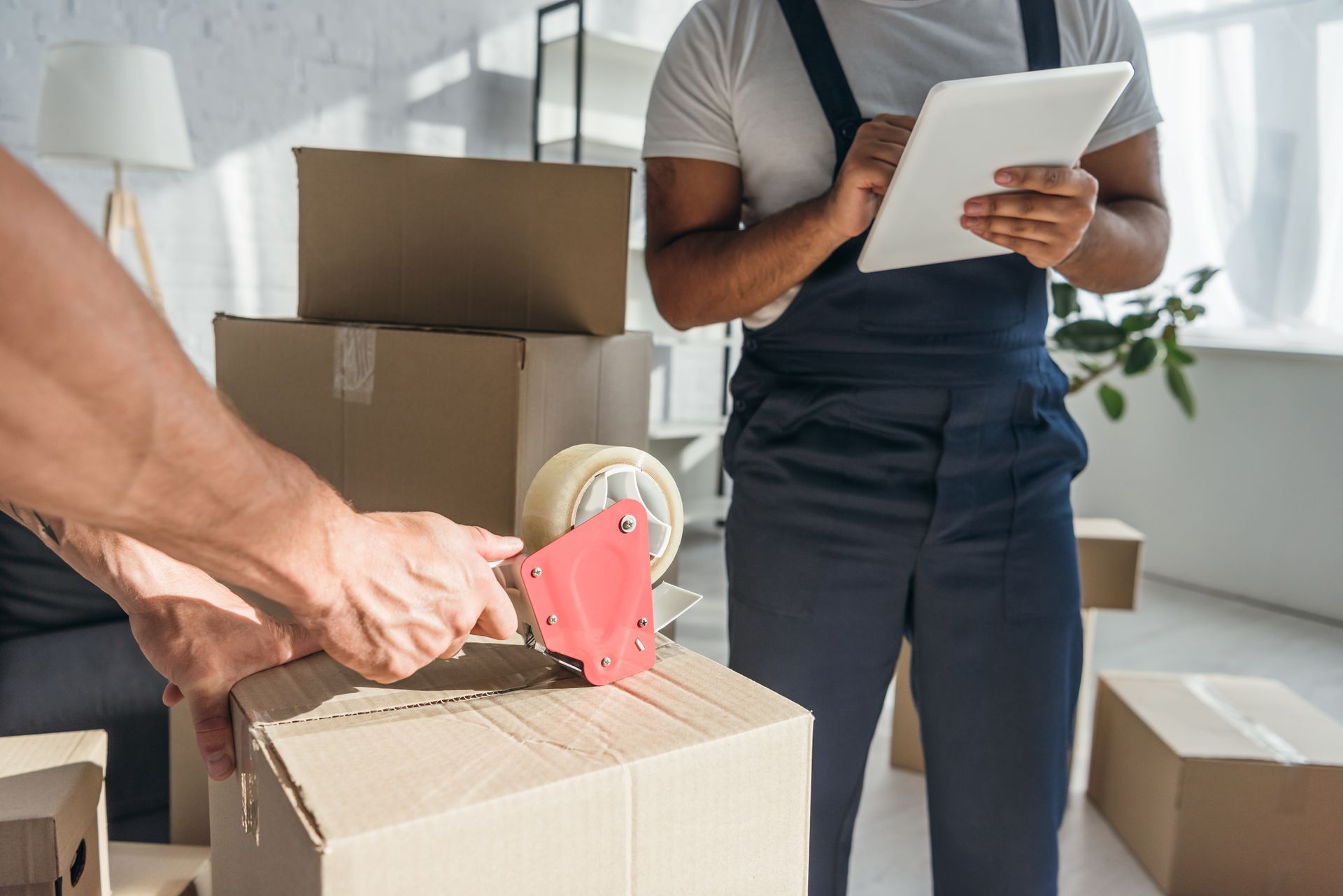 Des déménageurs emballent des cartons.