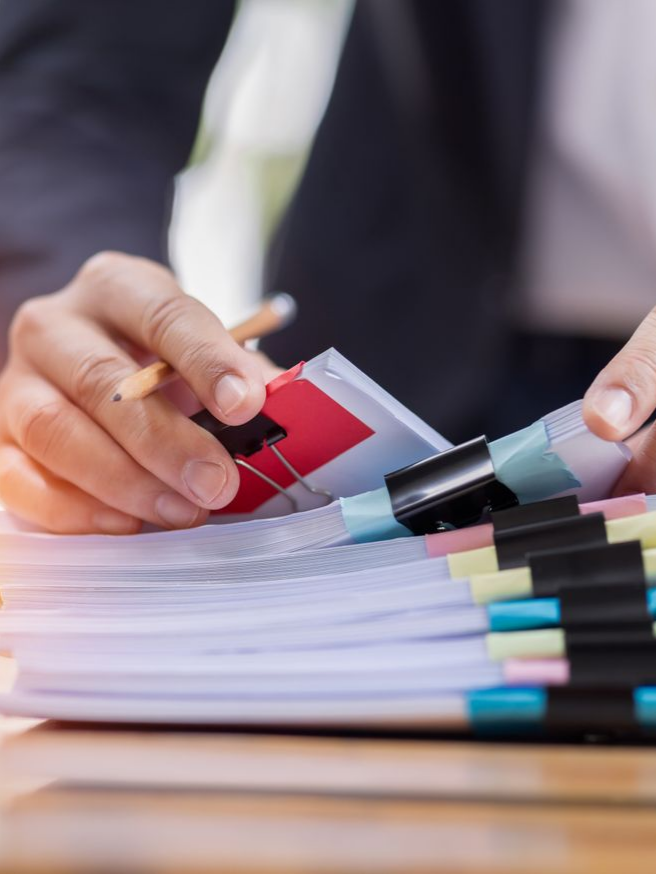 Les mains d'une personne triant une pile de documents.
