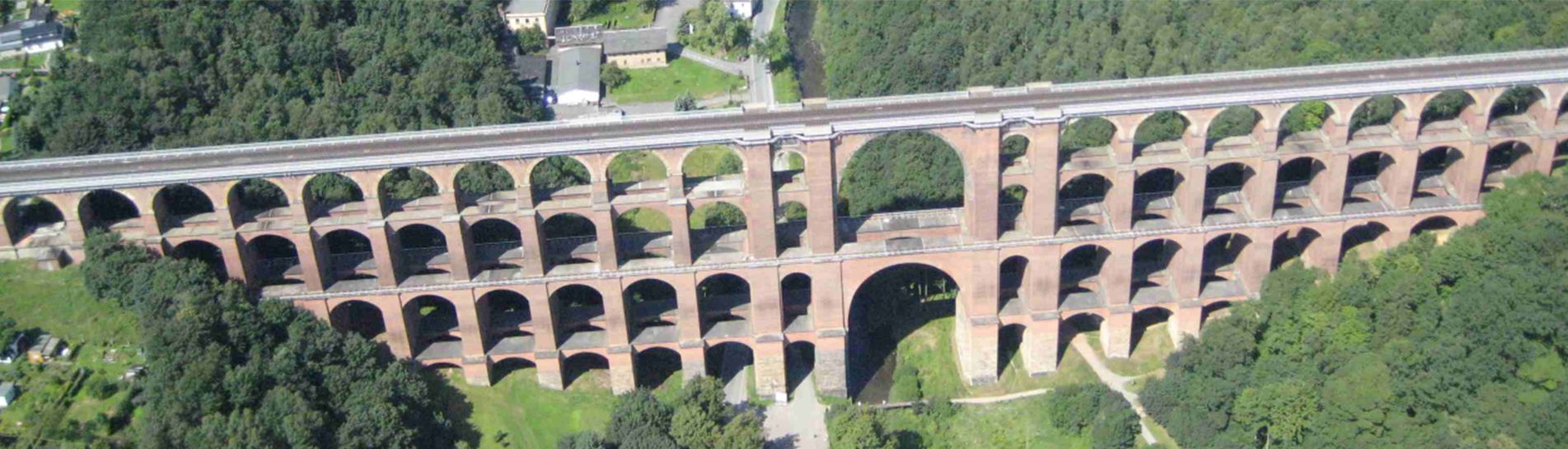 eine Luftaufnahme einer von Bäumen umgebenen Brücke