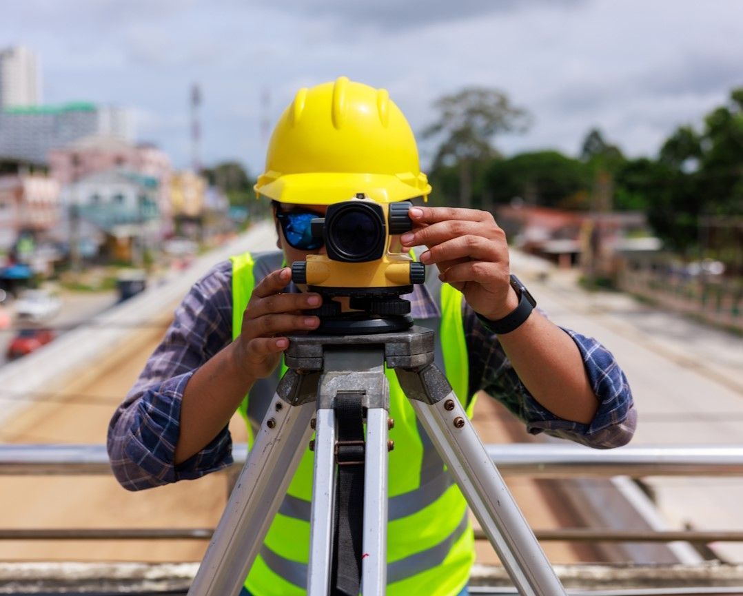 Vermessungsingenieur des Vermessungsbüros Hannover führt Ingenieurvermessung auf Baustelle durch