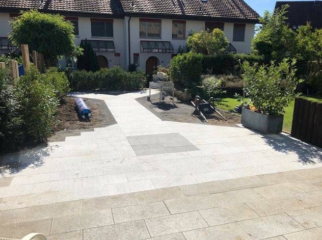 Ein weisses Haus mit einer Terrasse und einem Garten davor. Foto von FIERAMONTE GARTEN