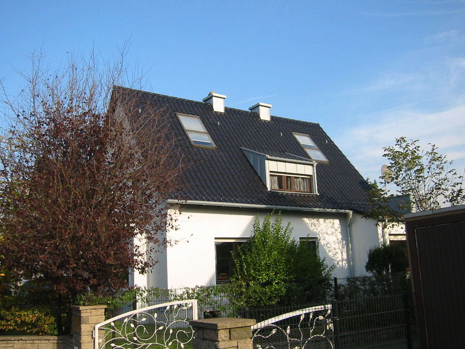 Foto | weißes Einfamilienhaus | schwarzes Dach 