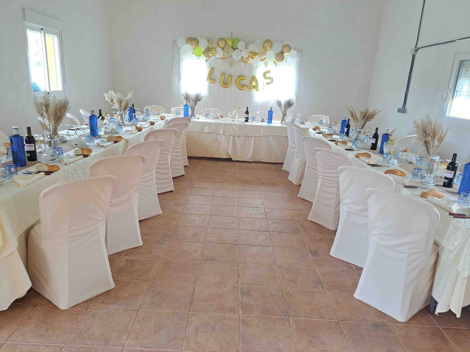 Una gran sala con mesas y sillas preparadas para una recepción de boda.