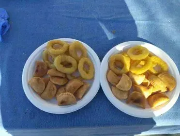 Dos platos de comida en una mesa, incluidos aros de cebolla.