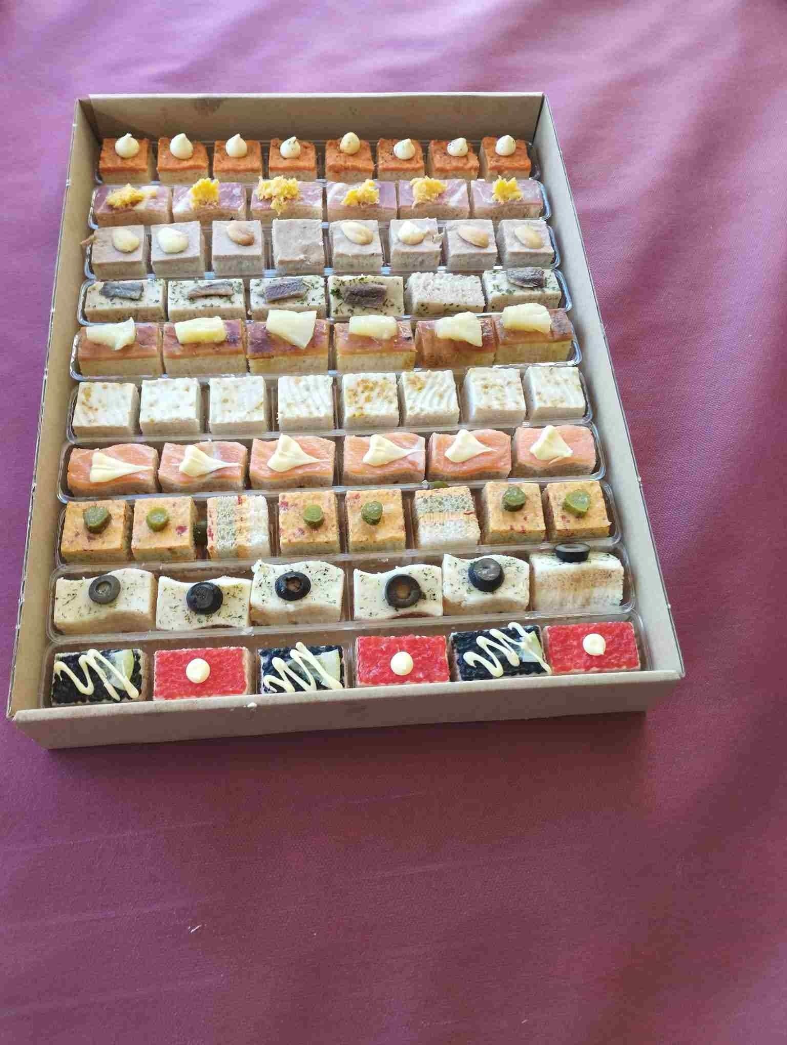 Una caja de cartón llena de una variedad de postres sobre una mesa.